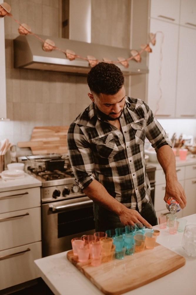 a man cutting a cake on a kitchen counter